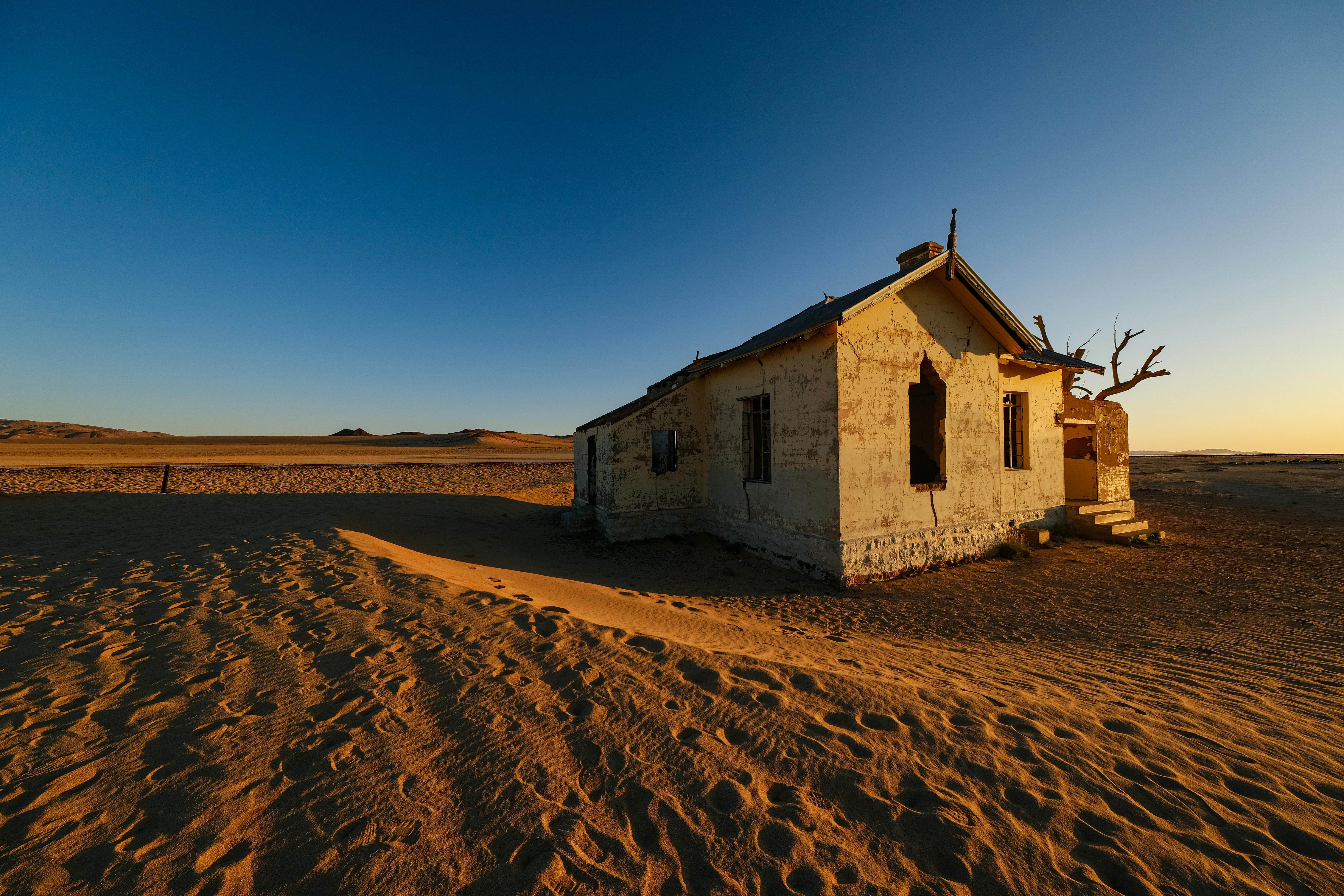 an old abandoned house in the desert at sunset