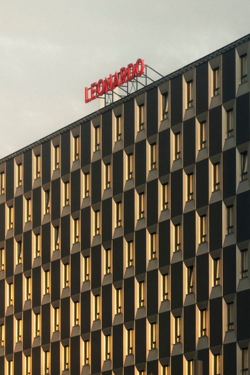 Free Striking modern building facade reflecting the sunset with geometric patterns and urban aesthetics. Stock Photo
