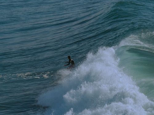Free Surfer catching waves in vibrant Taghazout, Morocco, an exhilarating ocean adventure. Stock Photo