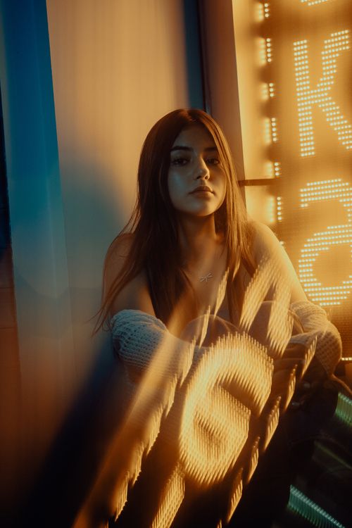 Free Portrait of a stylish woman illuminated by neon lights at twilight. Stock Photo