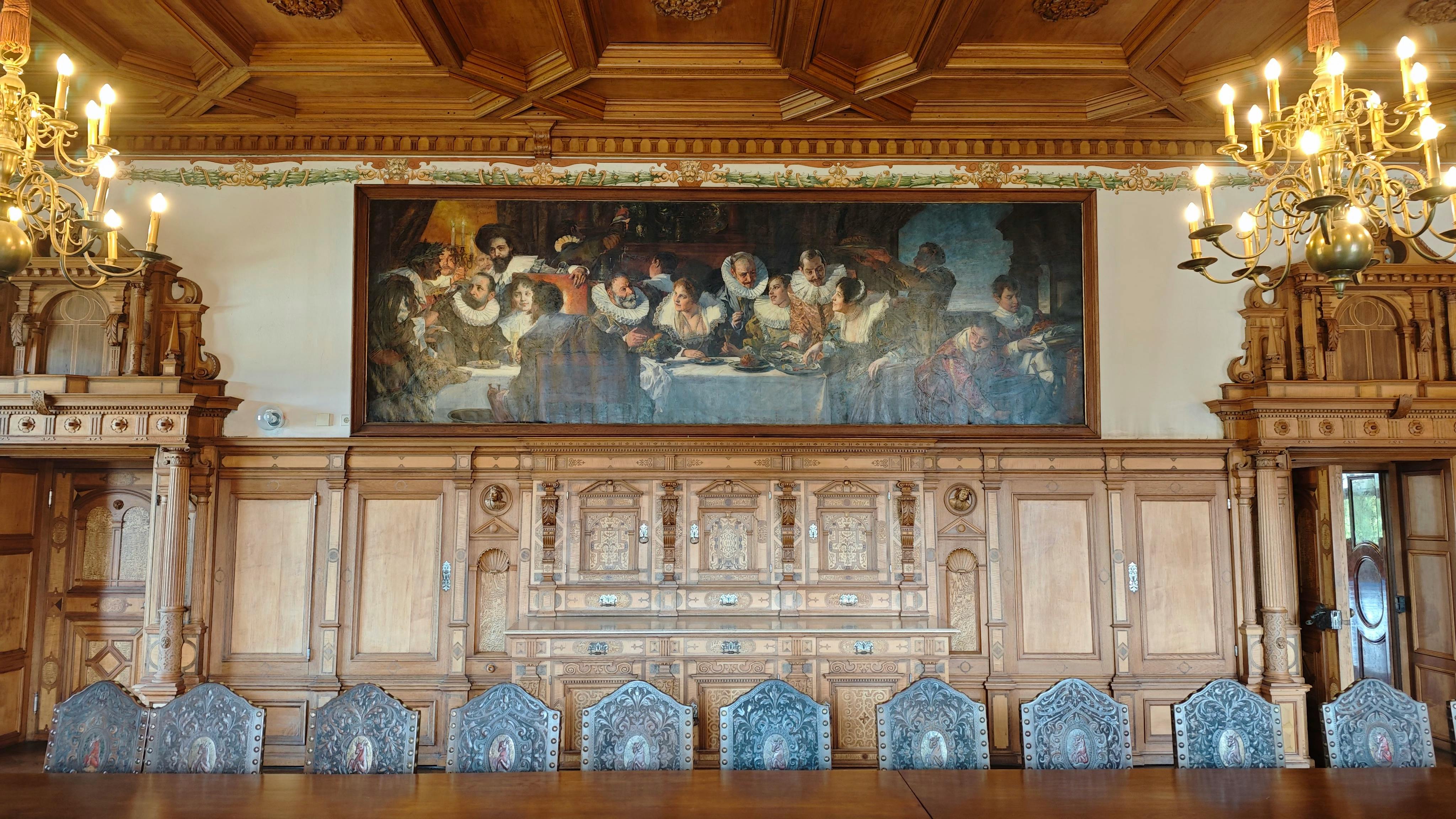 a large wooden table with a painting on the wall