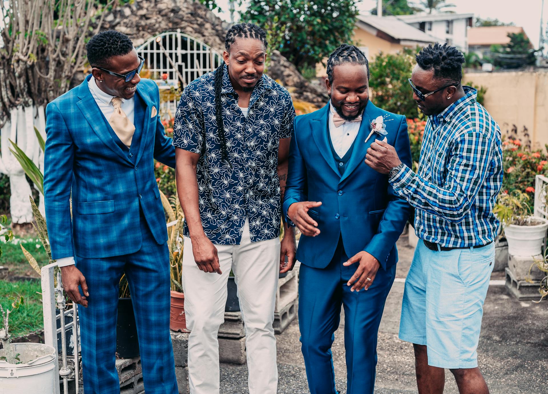 Four men celebrating together outdoors in Port of Spain, Trinidad and Tobago, showcasing friendship and fashion.