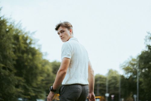 Free A young man turning back in a park, serene summer setting. Stock Photo