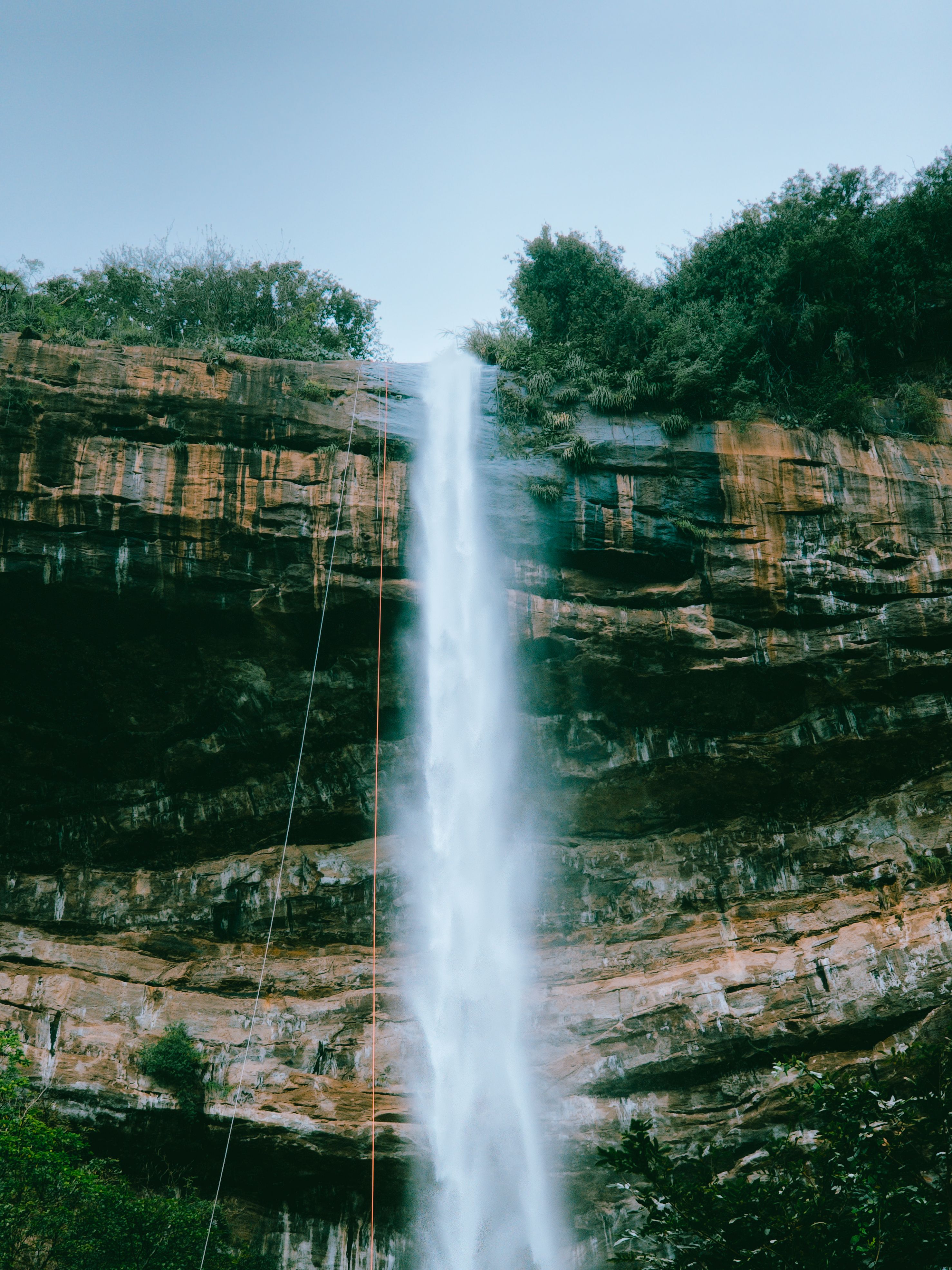 Stunning waterfall cascading down rocky cliffs surrounded by lush greenery in Ipu, Brazil.