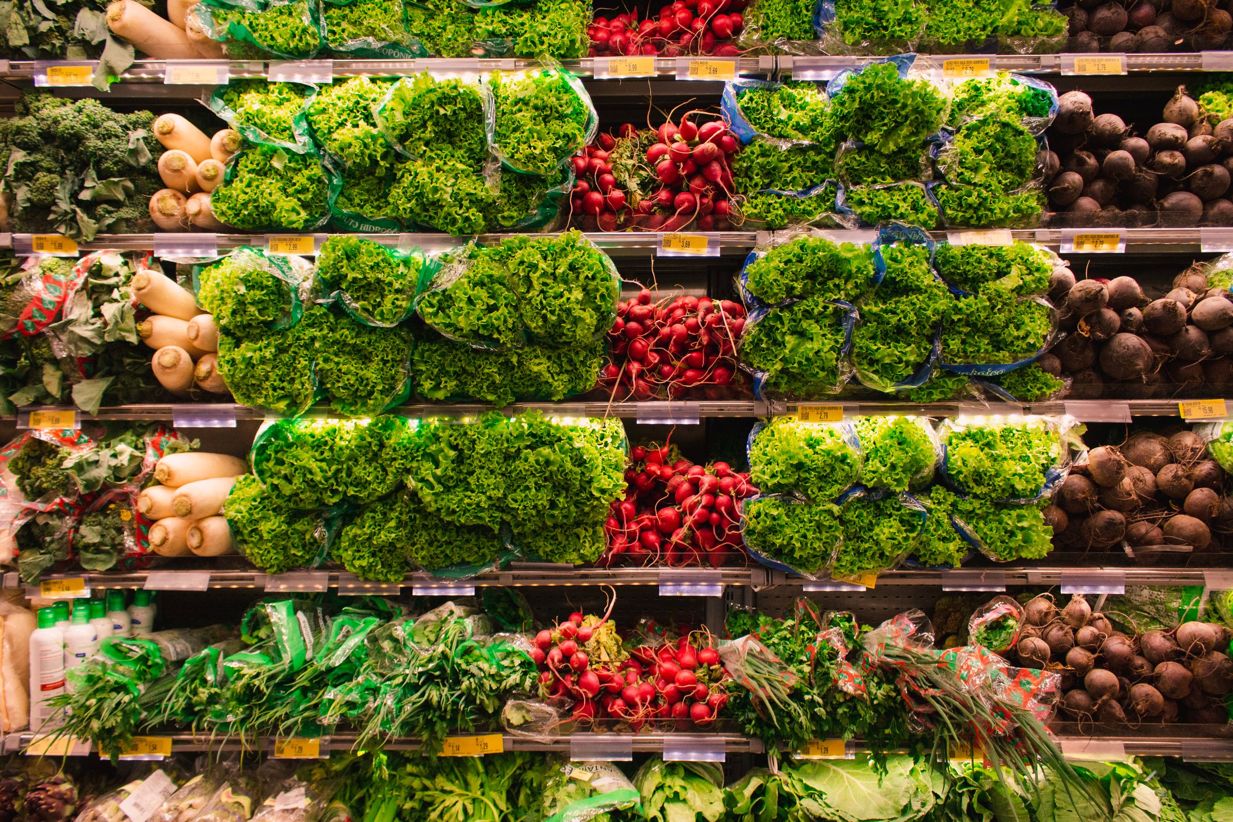 Dense supermarket shelving filled with produce, arranged in a tight grid