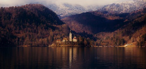 Фото церкви у озера и горы