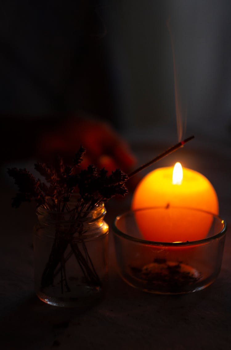 Close-Up Photo Of Lighted Incense Stick Near Candle