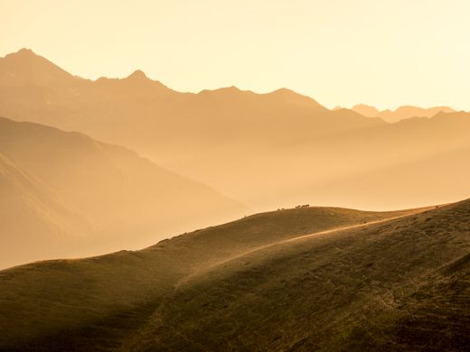 Rolling hills and mountain range at golden hour — photo by Juanjo Fuster on Pexels