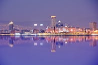 充满活力的夜间城市景观倒映在平静的河水中，展现出其现代建筑风貌