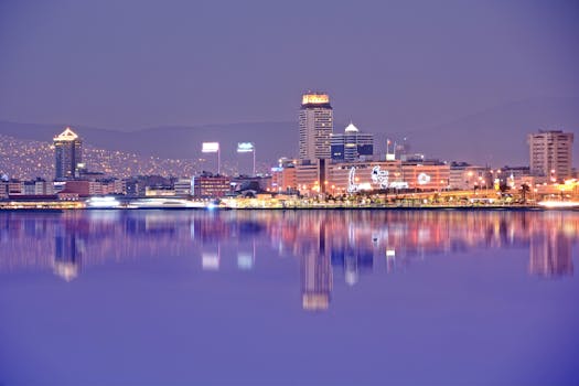 充满活力的夜间城市景观倒映在平静的河水中，展现出其现代建筑风貌