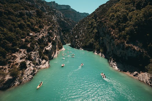 Kayakers enjoy turquoise waters surrounded by lush canyon walls, a perfect adventure setting.