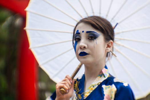 A woman in kimono poses outdoors with an umbrella, showcasing vibrant makeup and fashion in Mexico City.