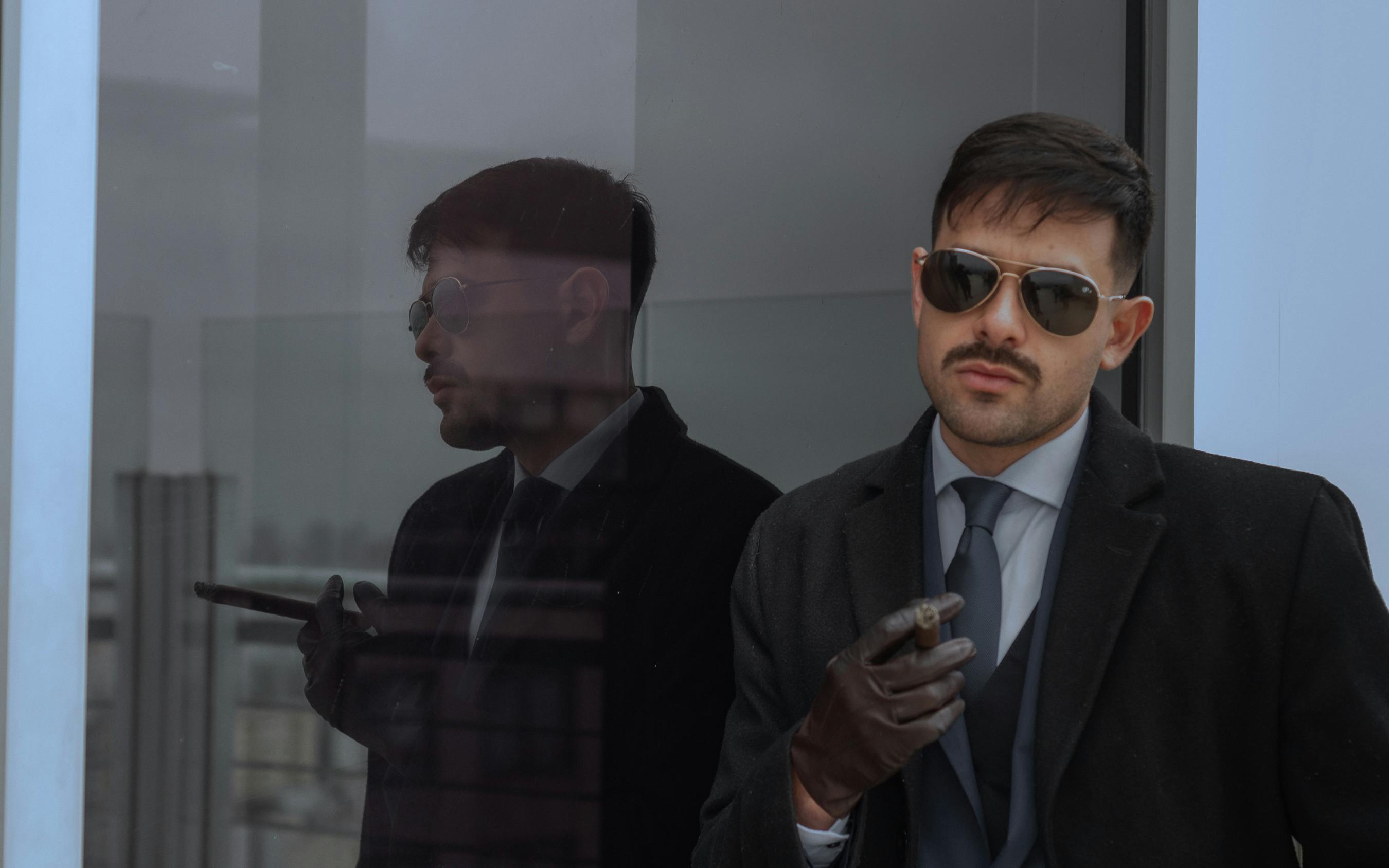 Business professional in sunglasses with a cigar in Buenos Aires office.