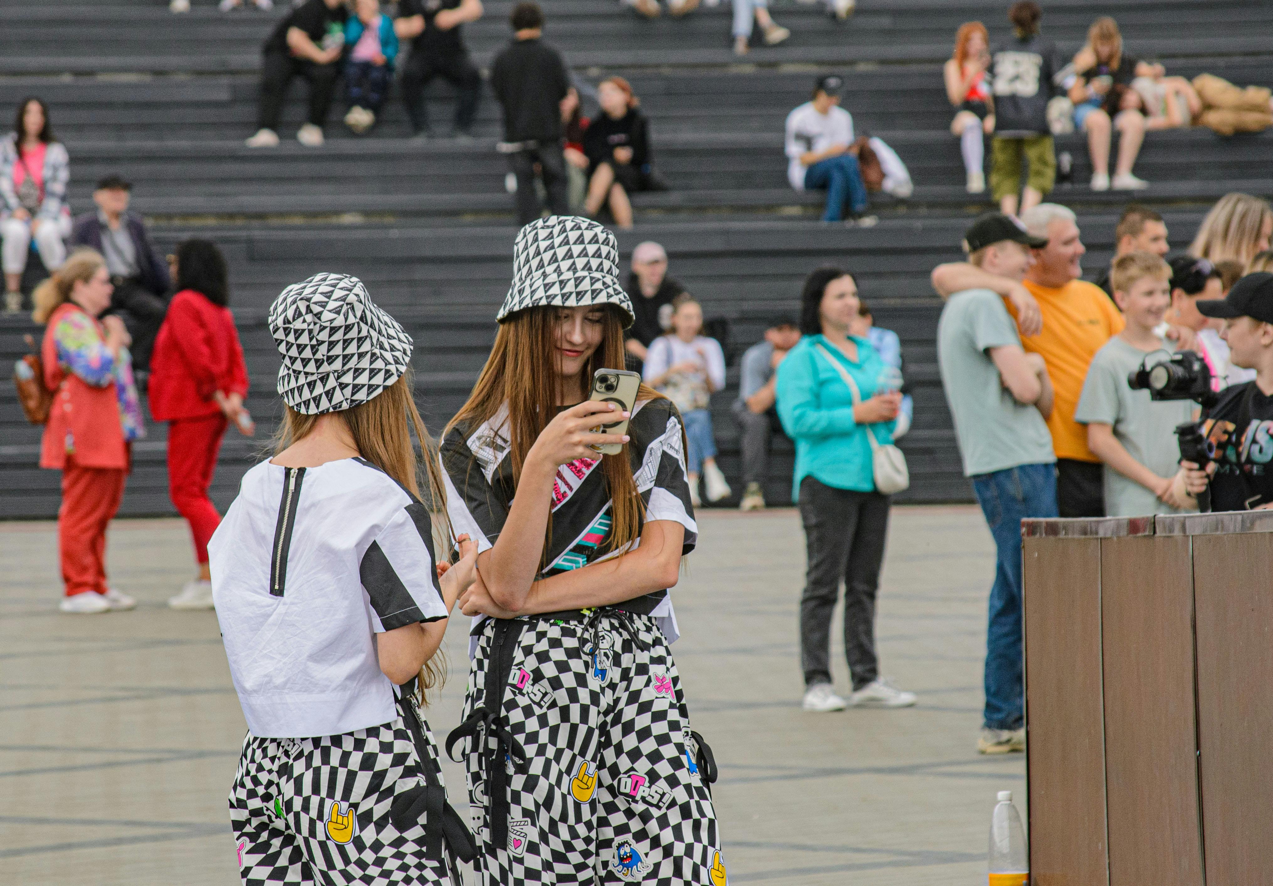 Two women in checkered outfits standing on a sidewalk