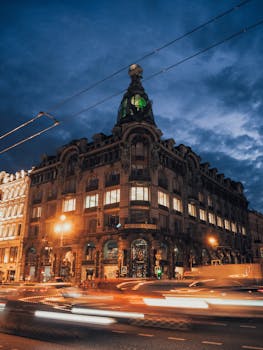 Night scene of Zinger House in Saint Petersburg with vibrant traffic under a dramatic sky.