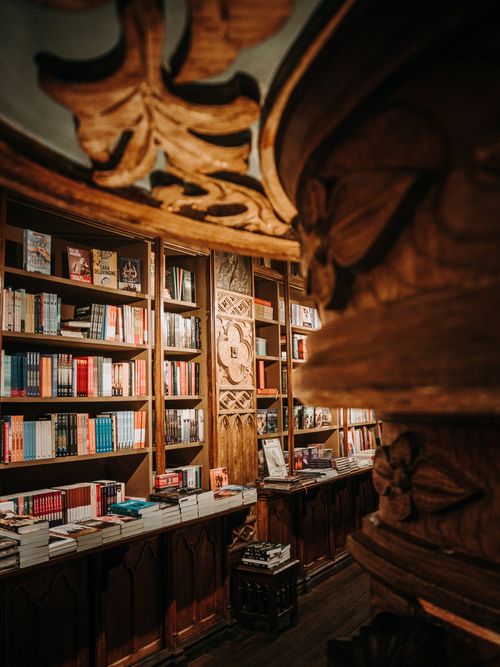 Free Explore an ornate bookstore interior in Porto, Portugal, showcasing wooden bookshelves filled with colorful books. Stock Photo