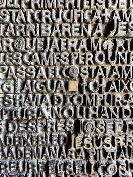 Close-up of carved text on a stone wall in Barcelona, Spain.