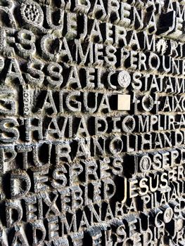 Close-up of the textured lettering on a wall of Sagrada Família in Barcelona, Spain. Architectural detail shot.