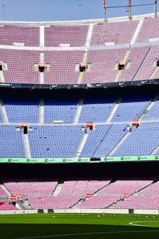 The empty Camp Nou Stadium in Barcelona showcases vibrant rows of seats and a clear soccer field.