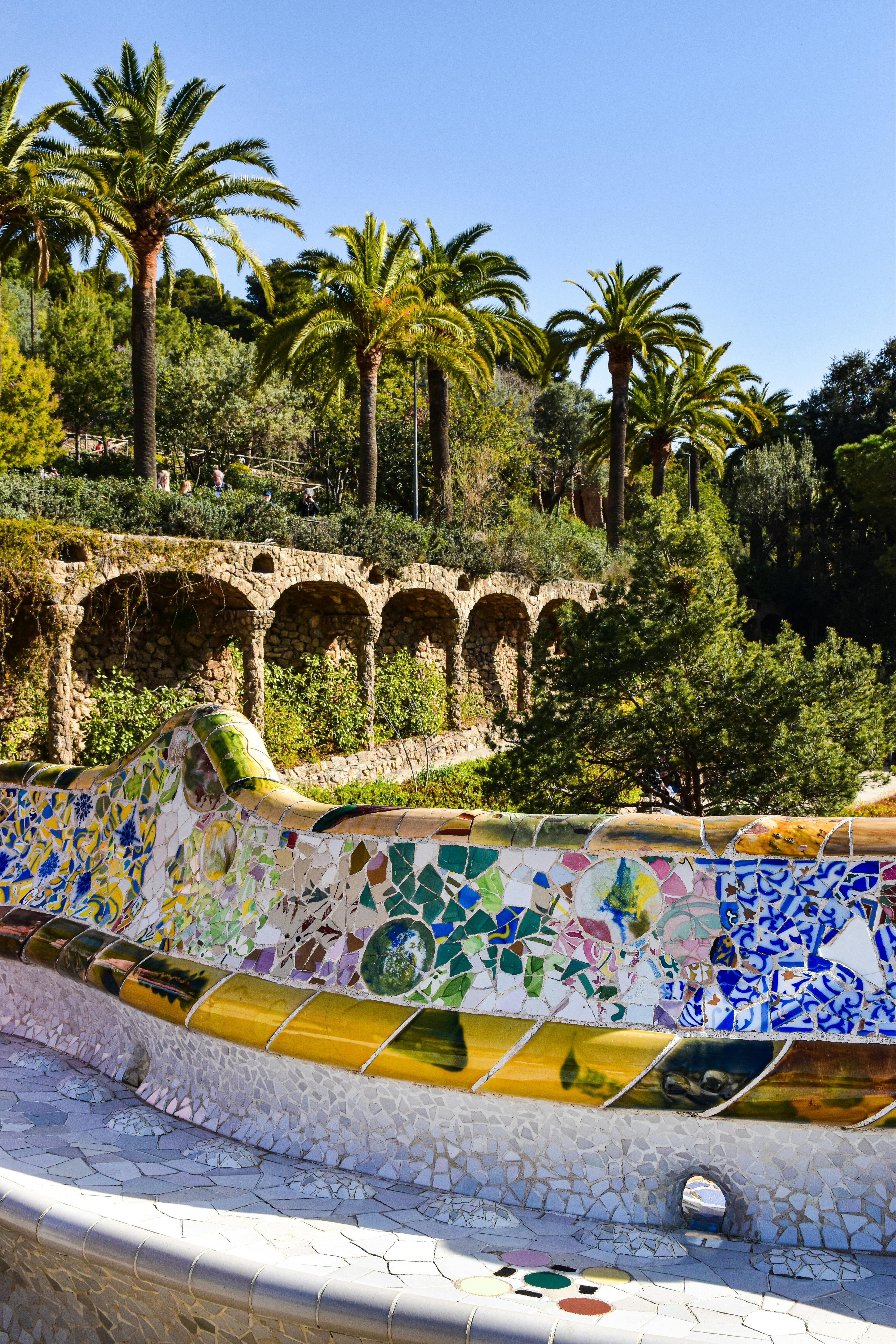 a colorful mosaic wall with palm trees in the background