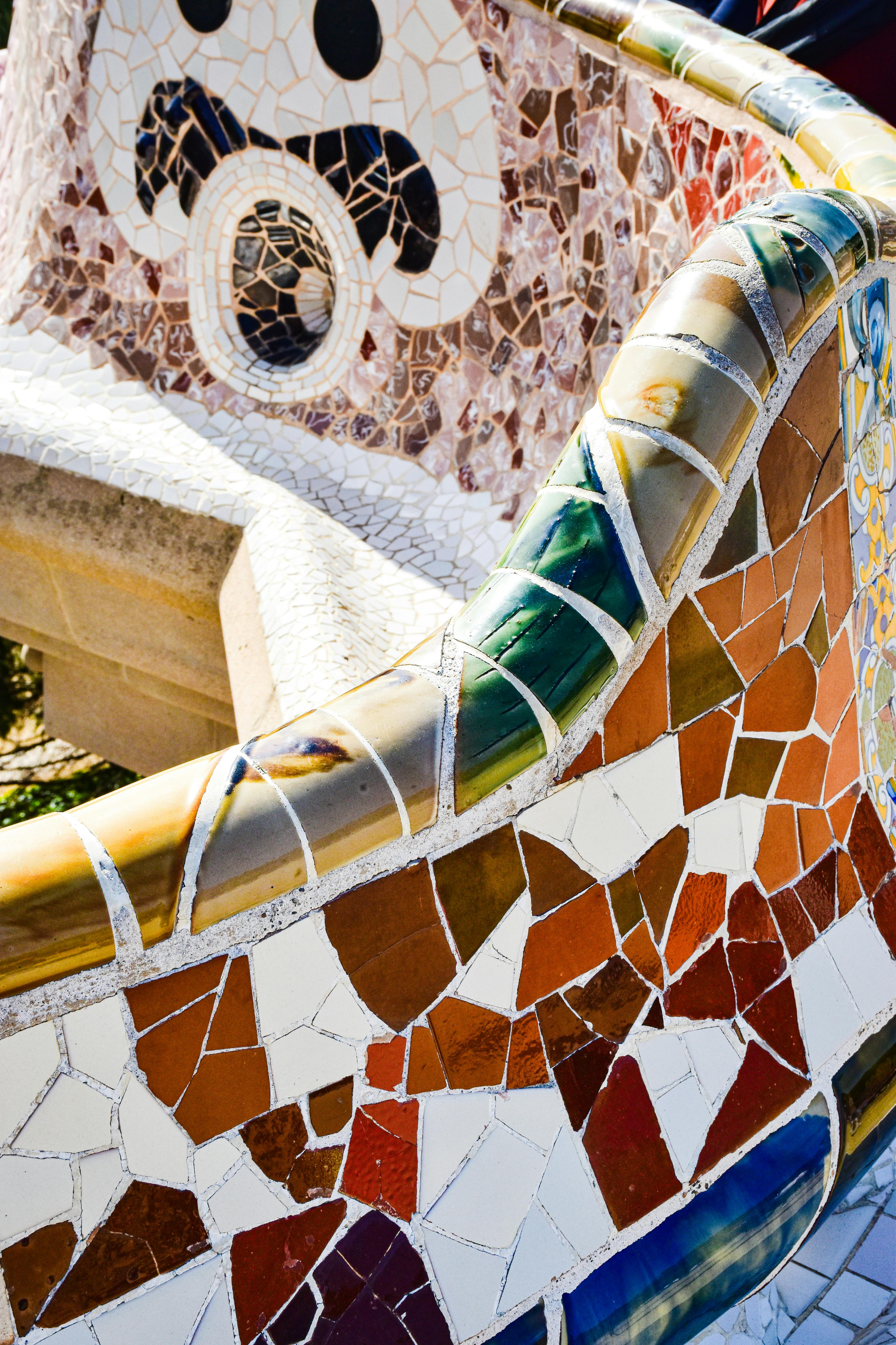 a close up of a mosaic bench with colorful designs