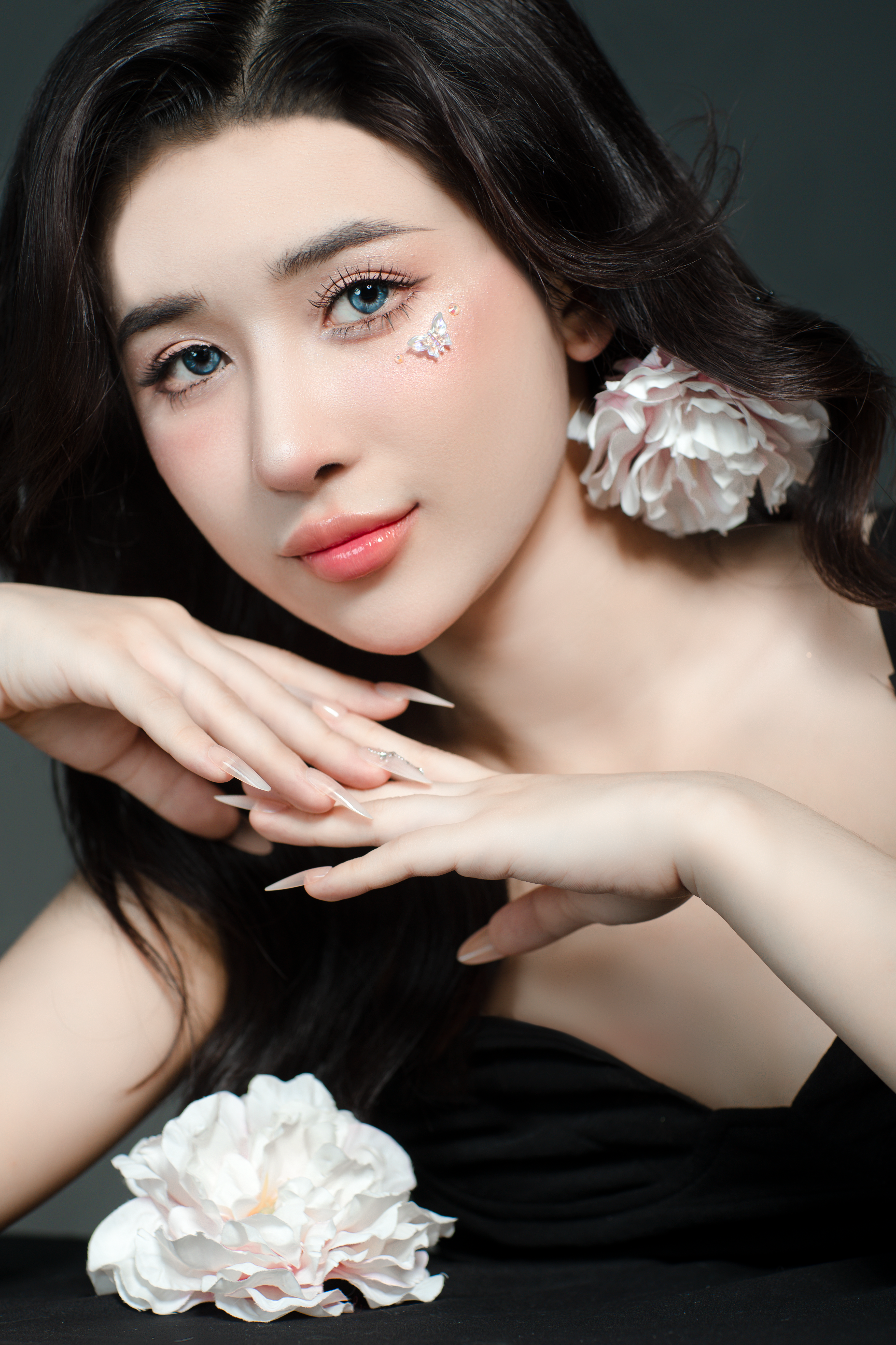 Stunning portrait of a young woman with cherry blossom makeup and flowers.