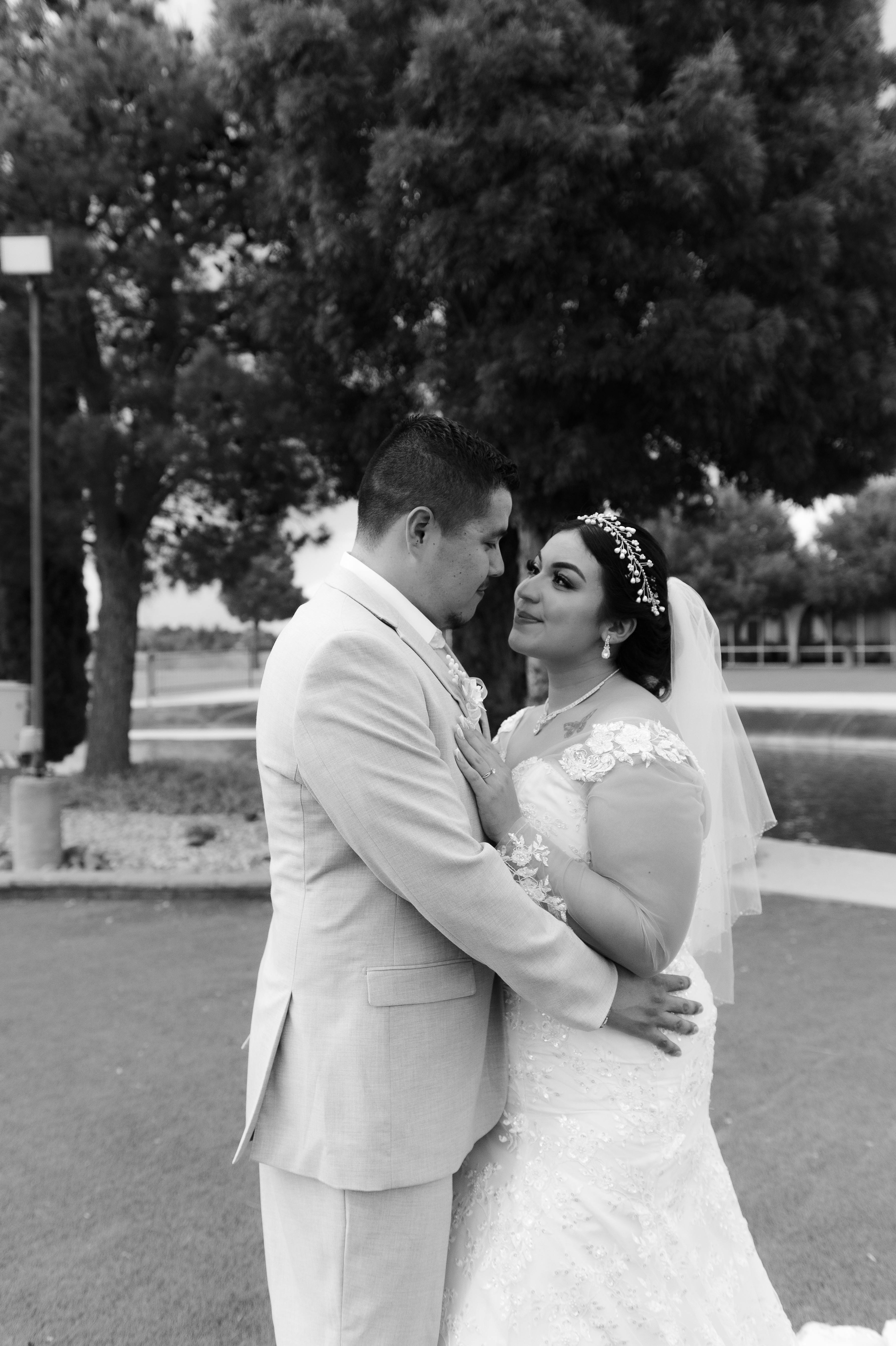 a bride and groom standing in front of a pond