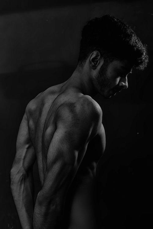 Free Dramatic black and white portrait of a shirtless muscular male model displaying strength. Stock Photo