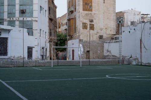 Free An empty soccer field in the heart of Jeddah's historic district, surrounded by traditional architecture. Stock Photo