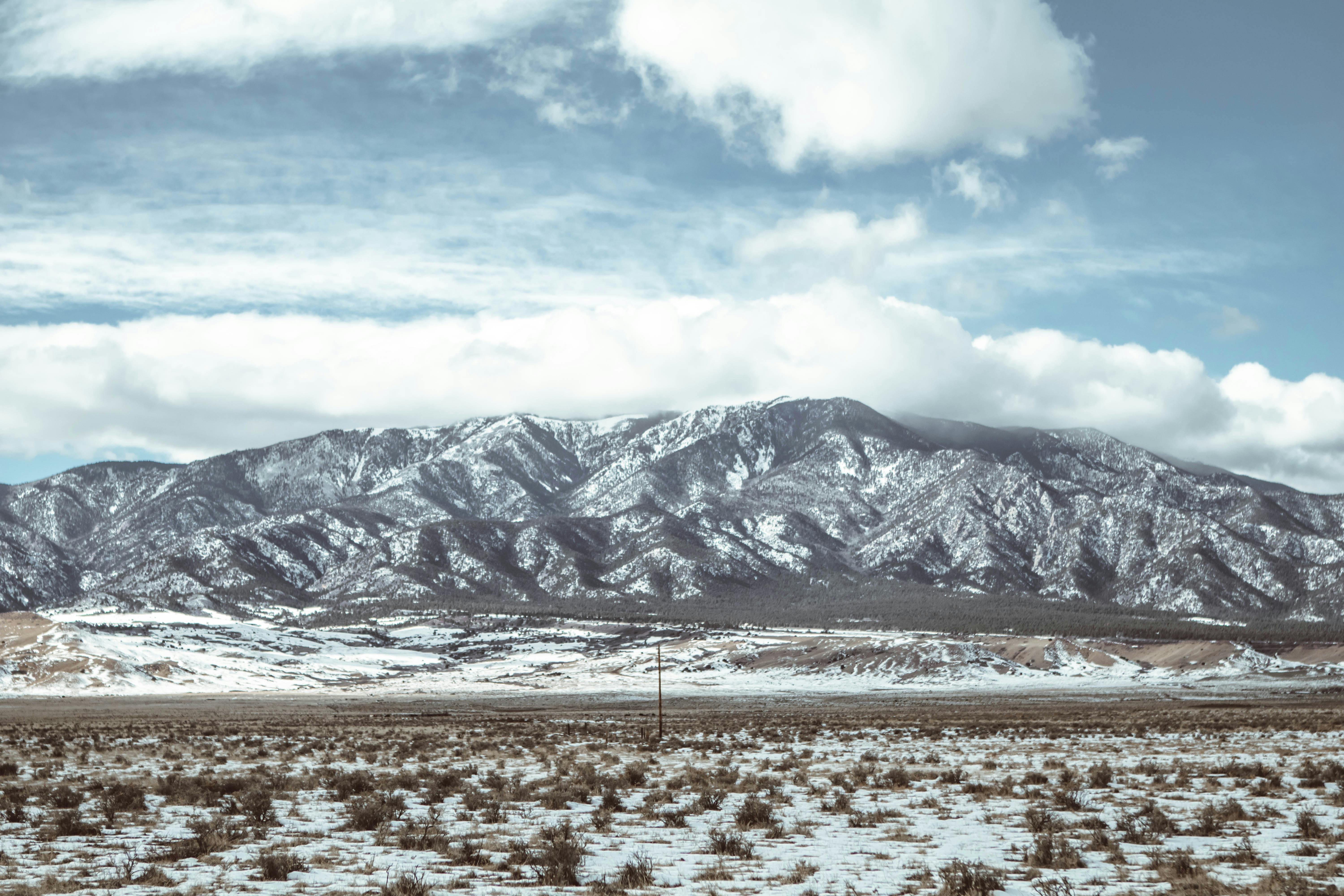 a snowy landscape with mountains in the background