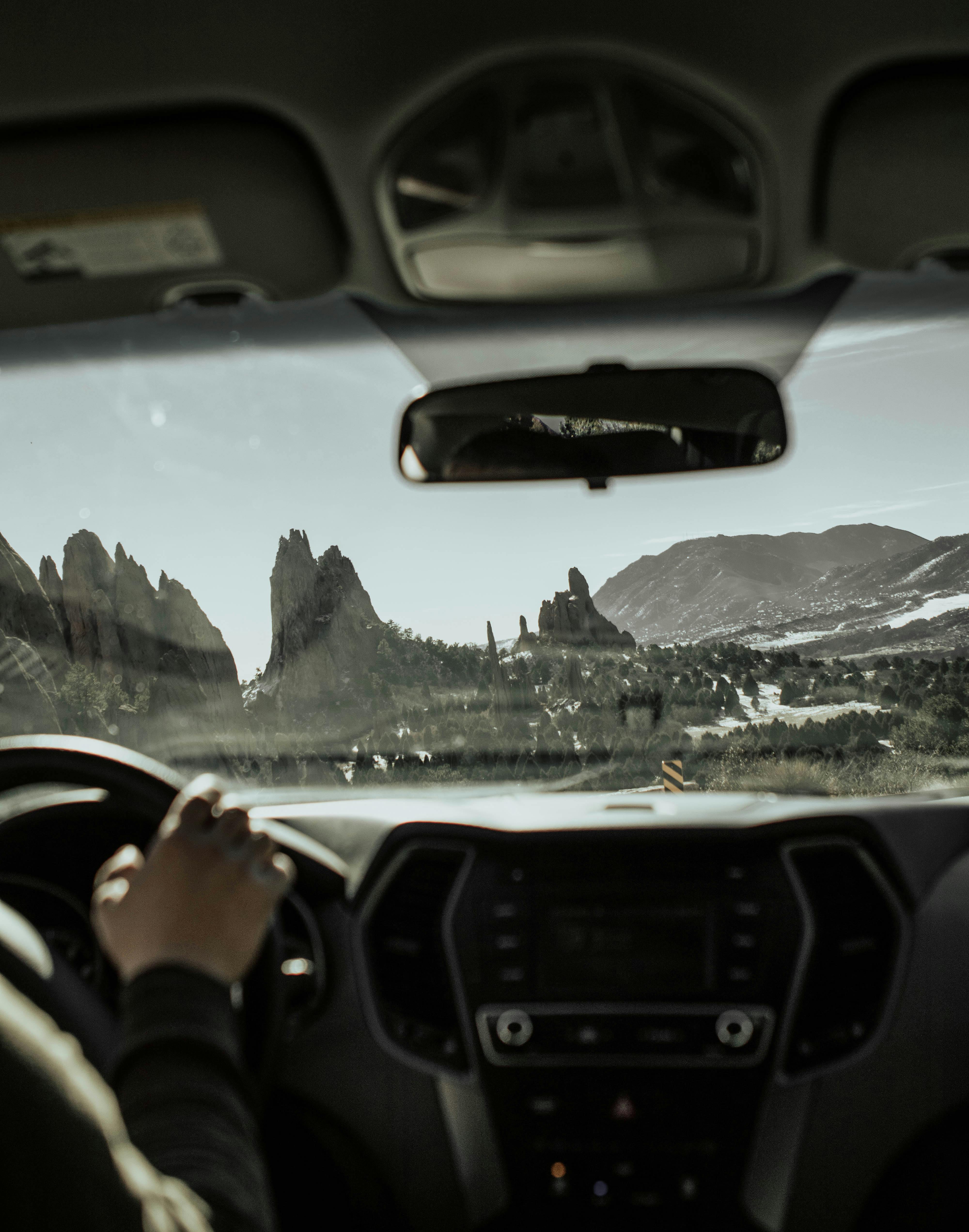 a person driving a car with mountains in the background