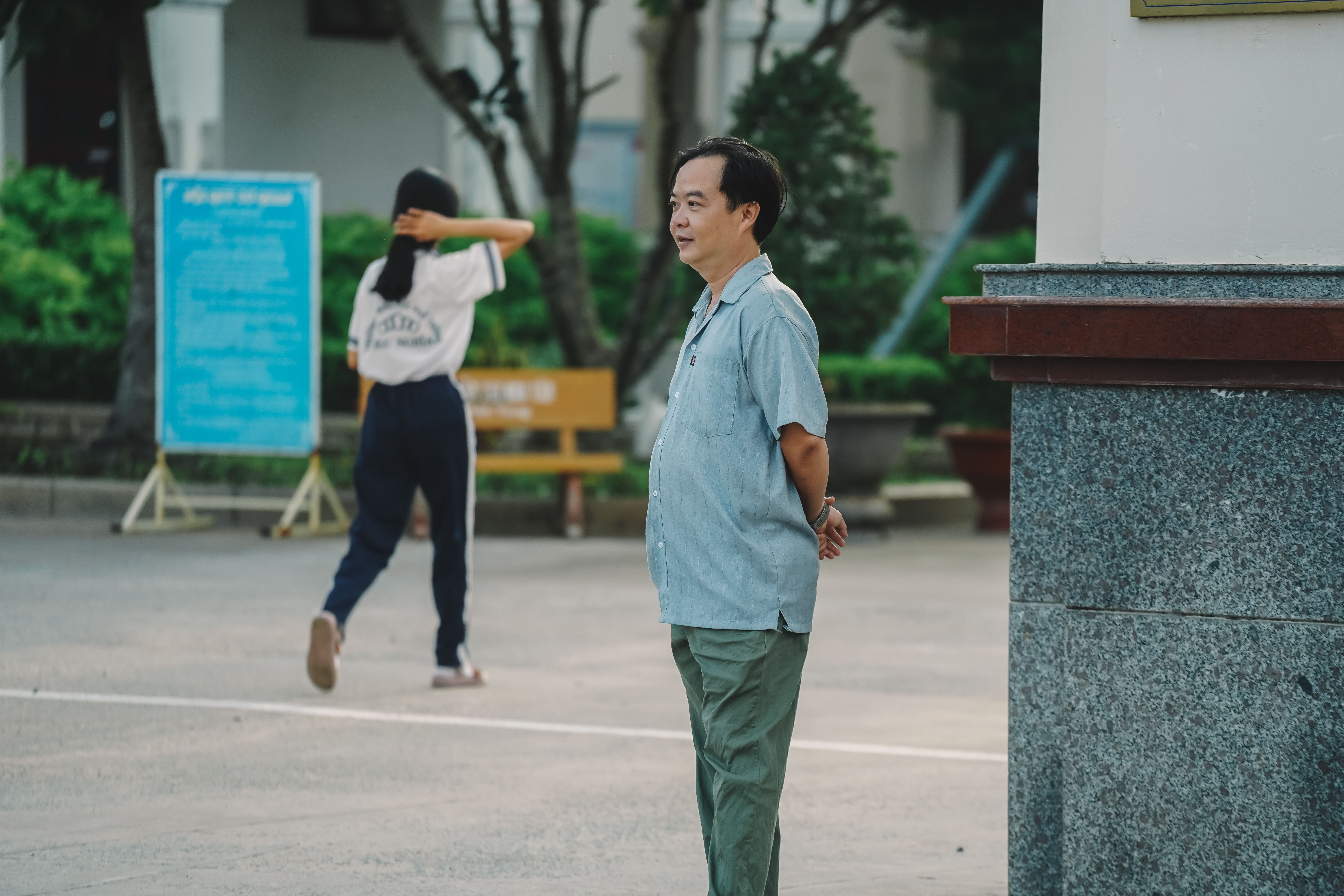 Người quan sát đứng trên vỉa hè ghi thời gian và biển số phương tiện, giữ khoảng cách an toàn