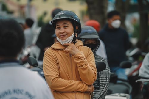 Free A casual street scene capturing people wearing helmets and masks. Stock Photo