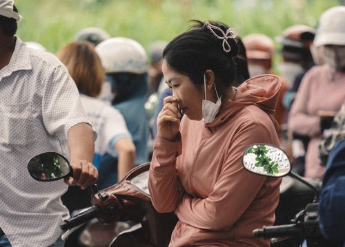 Free A bustling street with people wearing masks on scooters, reflecting urban life. Stock Photo