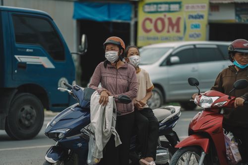 Free People wearing masks while waiting in traffic on motorbikes in the city. Stock Photo