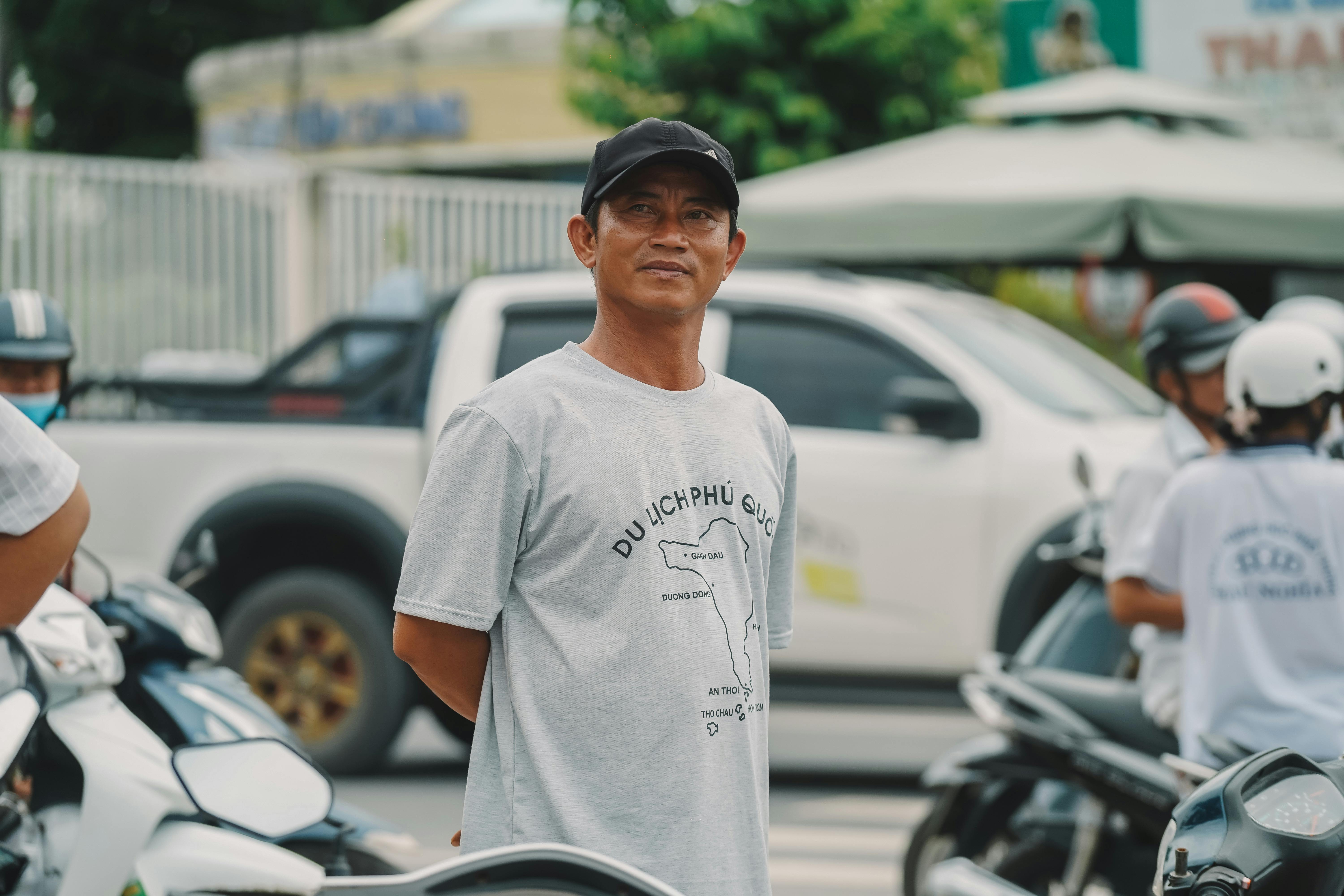 a man standing on the street with a group of motorcycles