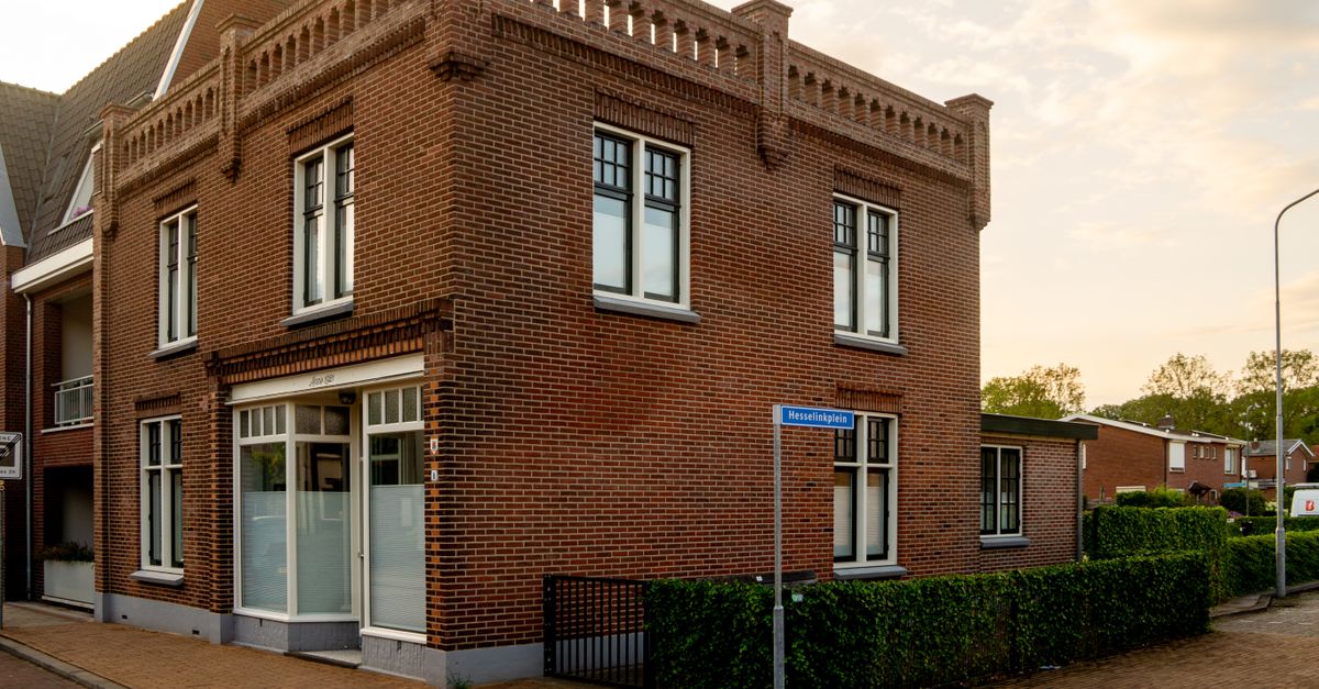 A charming two-story brick building located on a serene street corner in a quiet neighborhood.