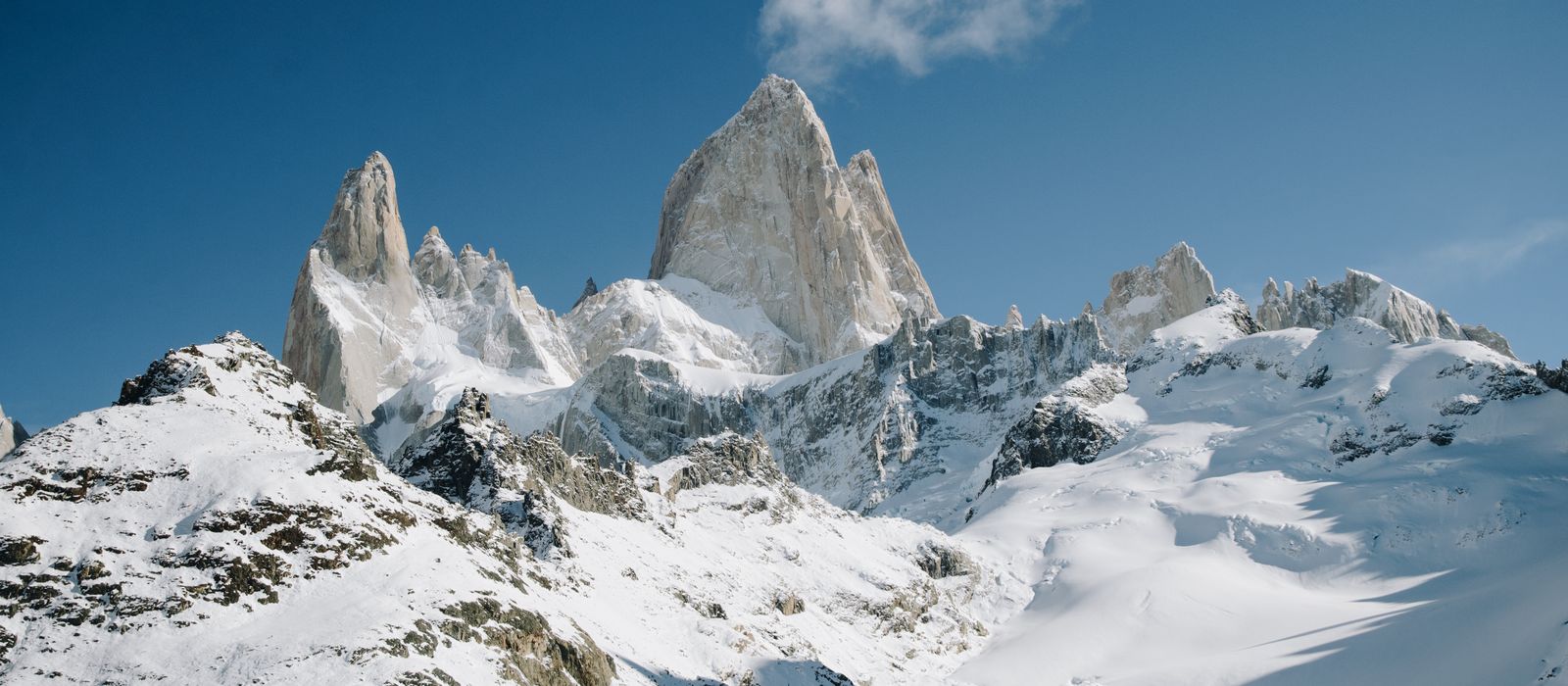 The jagged snow-covered spires of the Fitz Roy massif under a clear sky.