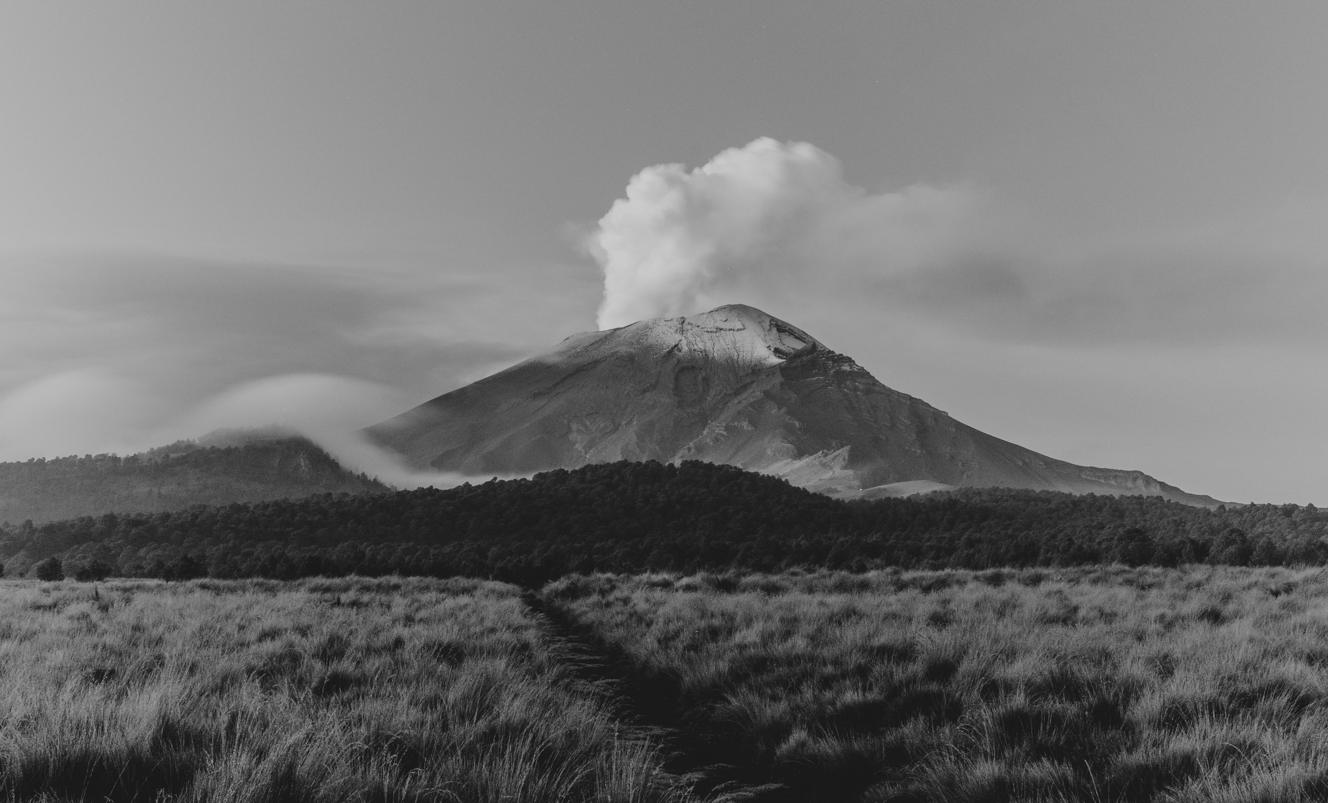 Captivating black and white view of a volcanic landscape with meadow.