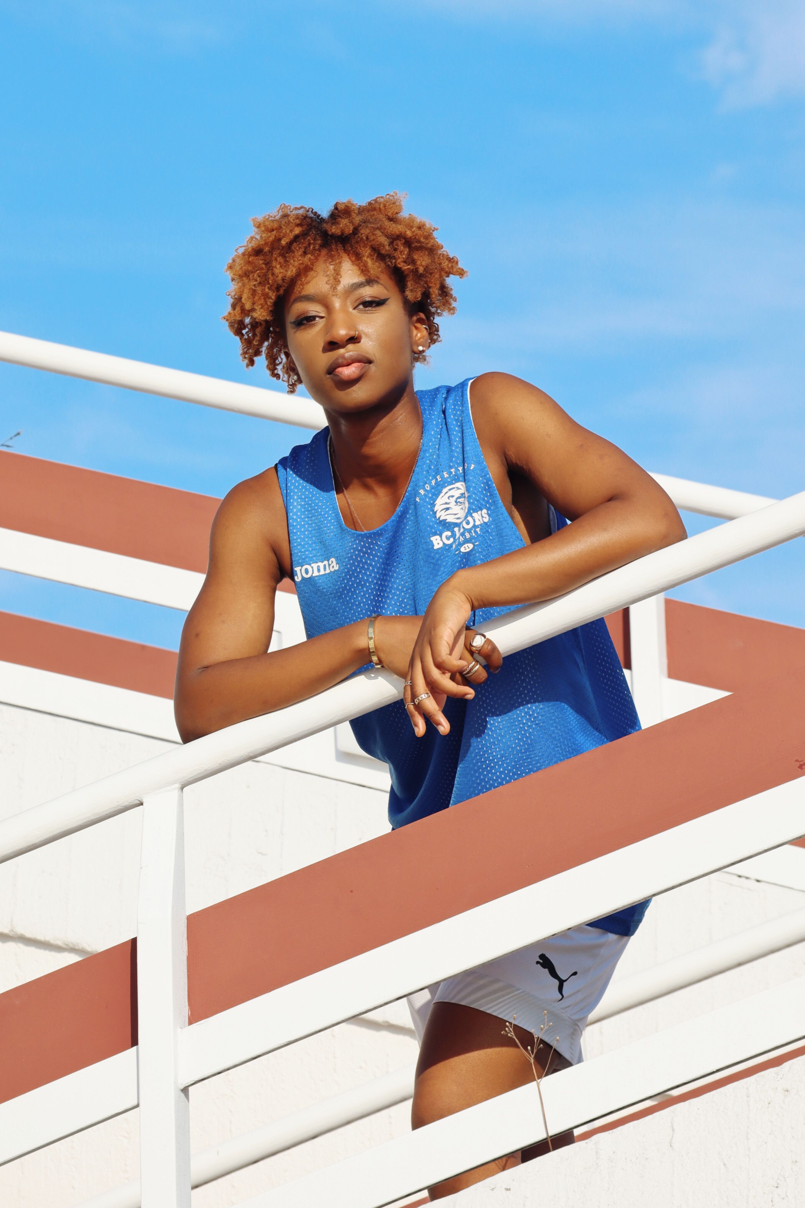 African American woman posing on railings in Berlin with a stylish look. Urban fashion portrait.