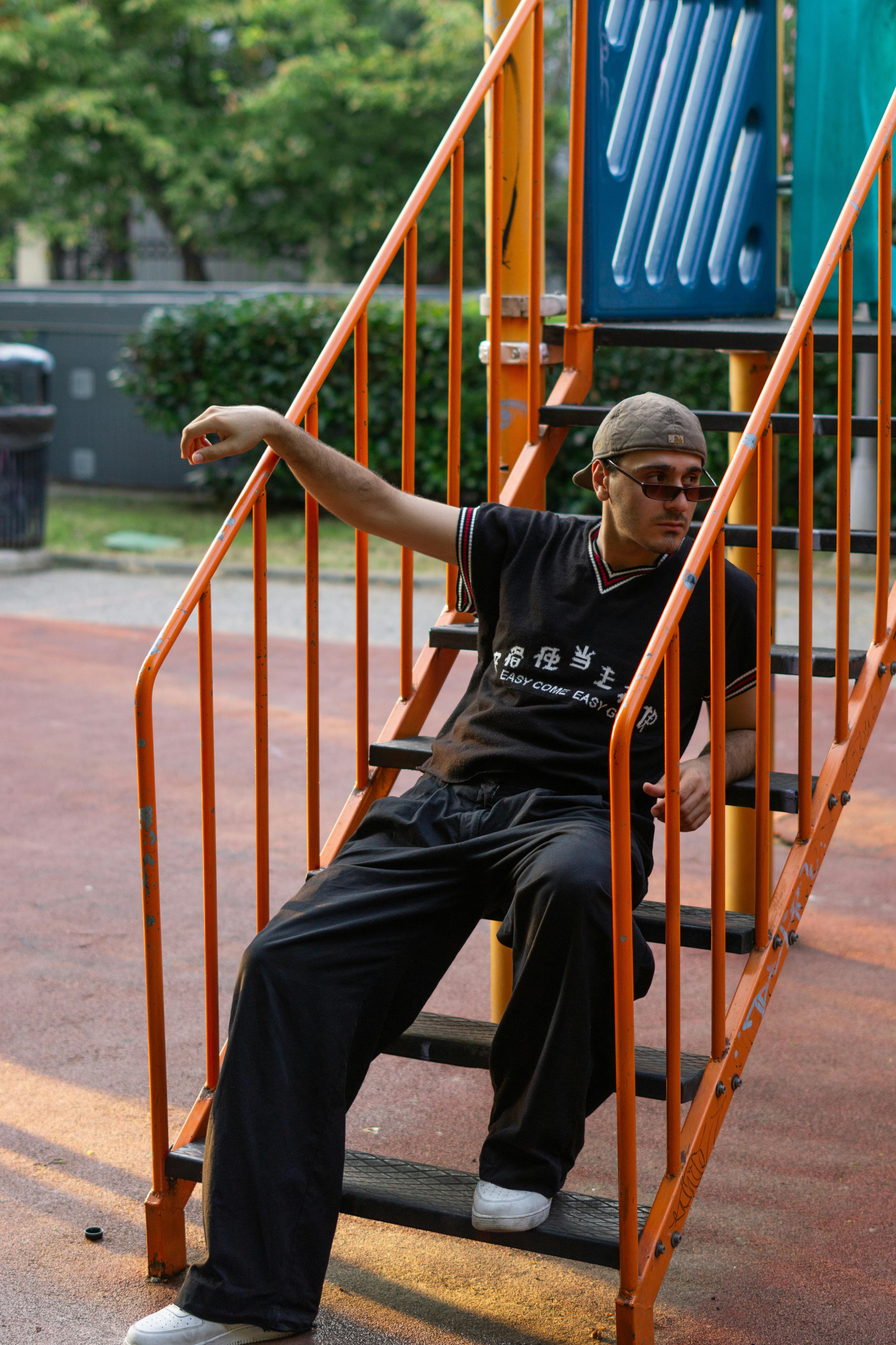 a man sitting on a slide in a park