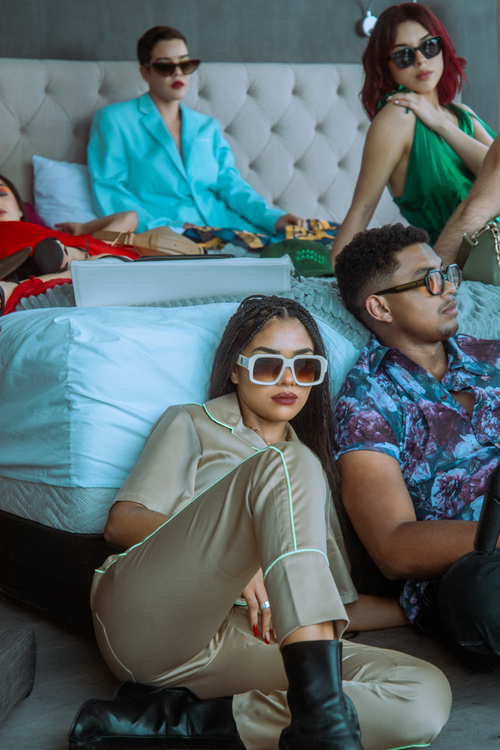 Free Group of adults in trendy outfits lounging indoors in a modern fashion setting. Stock Photo