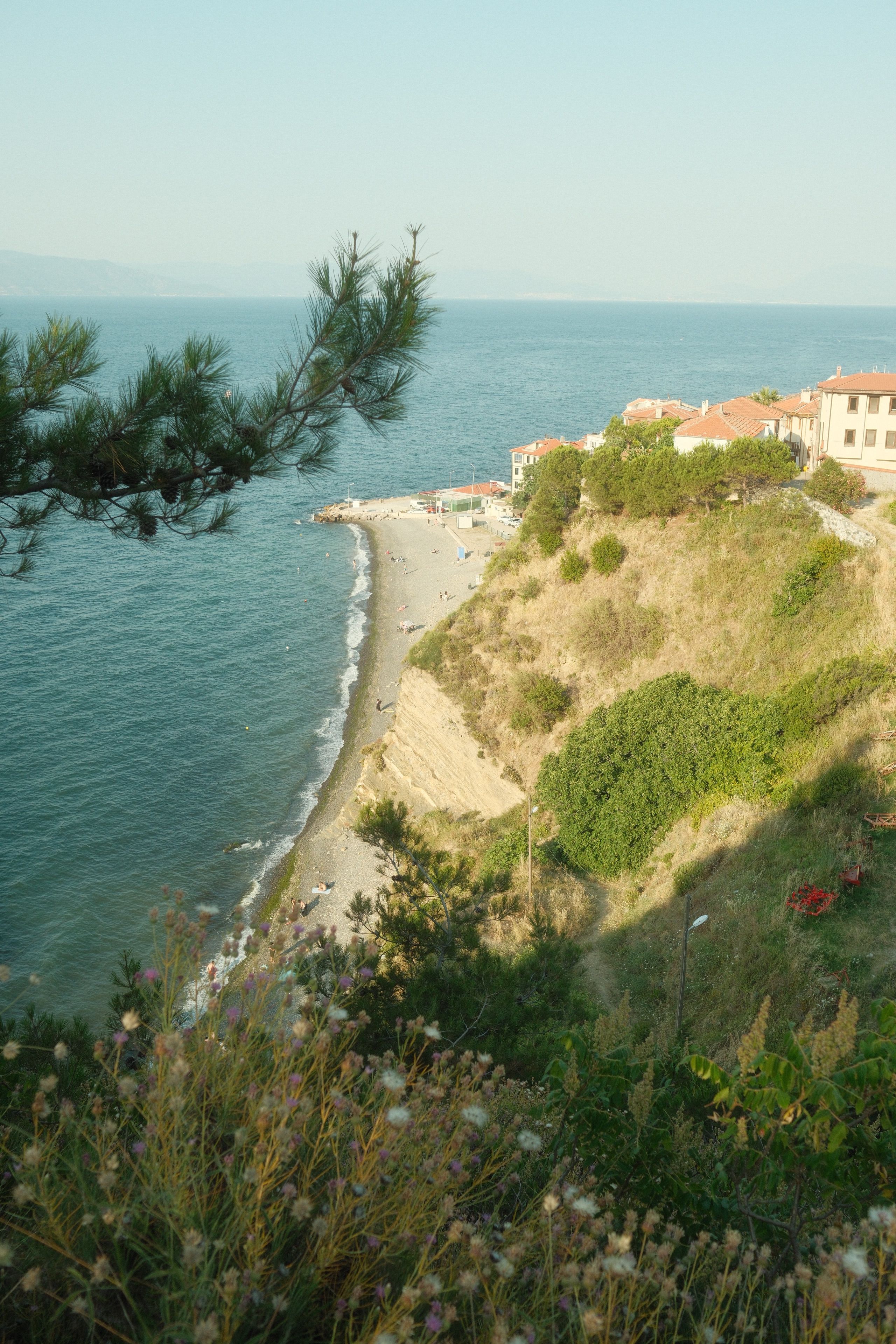 Tranquil coastal landscape with cliffs and clear blue waters in summer.