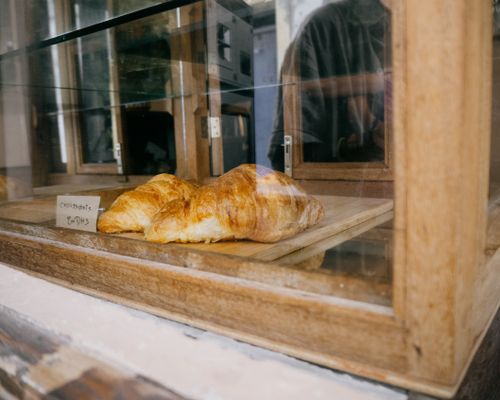 Free Golden croissant in a wooden display case at a bakery in Essaouira, Morocco. Stock Photo