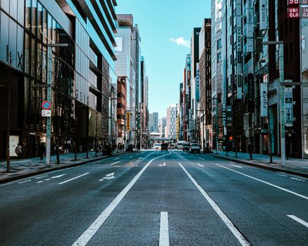 A bustling street in Tokyo with skyscrapers, traffic, and modern architecture.