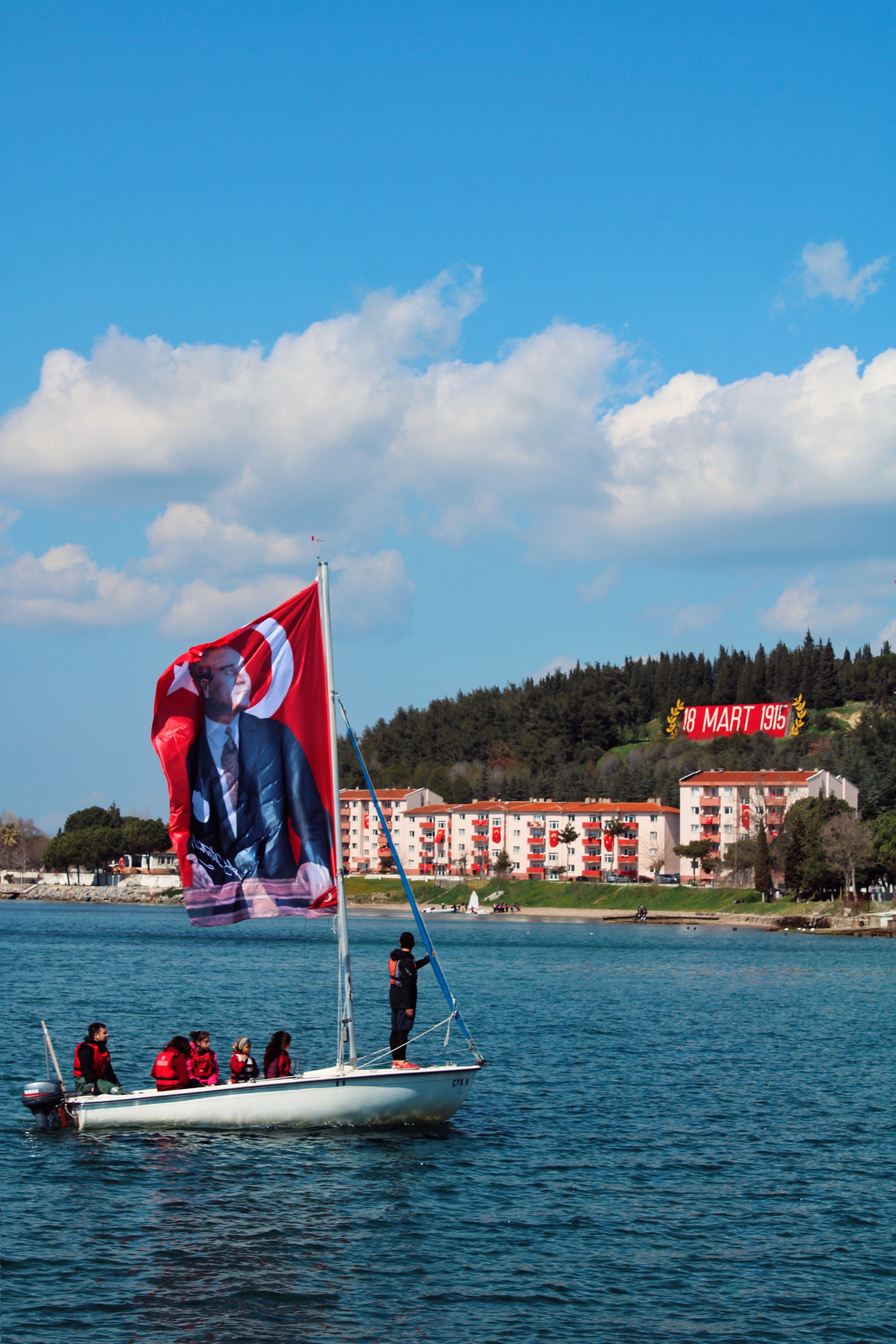 Sailboat with Turkish flag and portrait in Çanakkale, celebrating a historical event.
