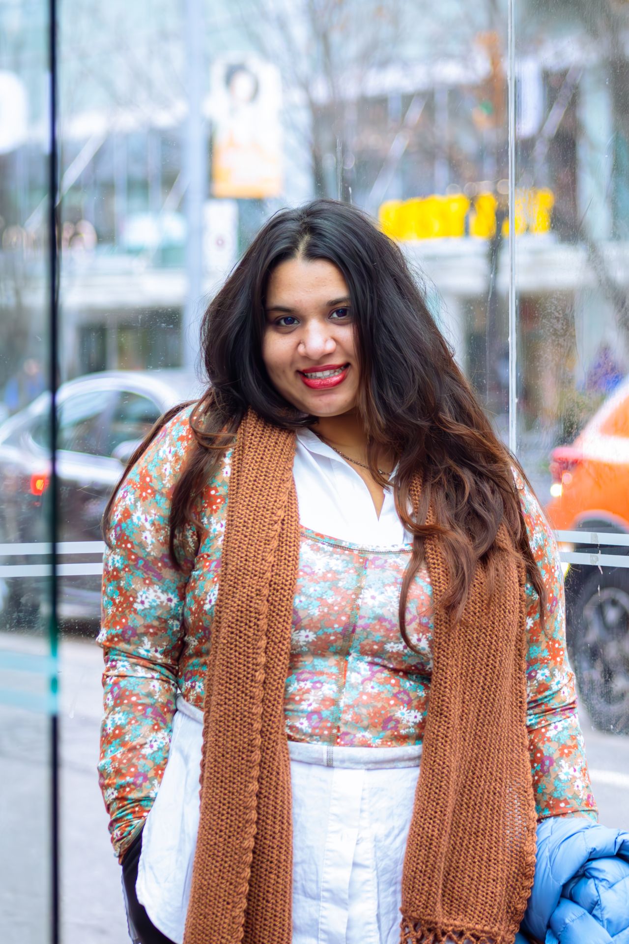 Smiling woman in Toronto wearing a chunky rust knit scarf