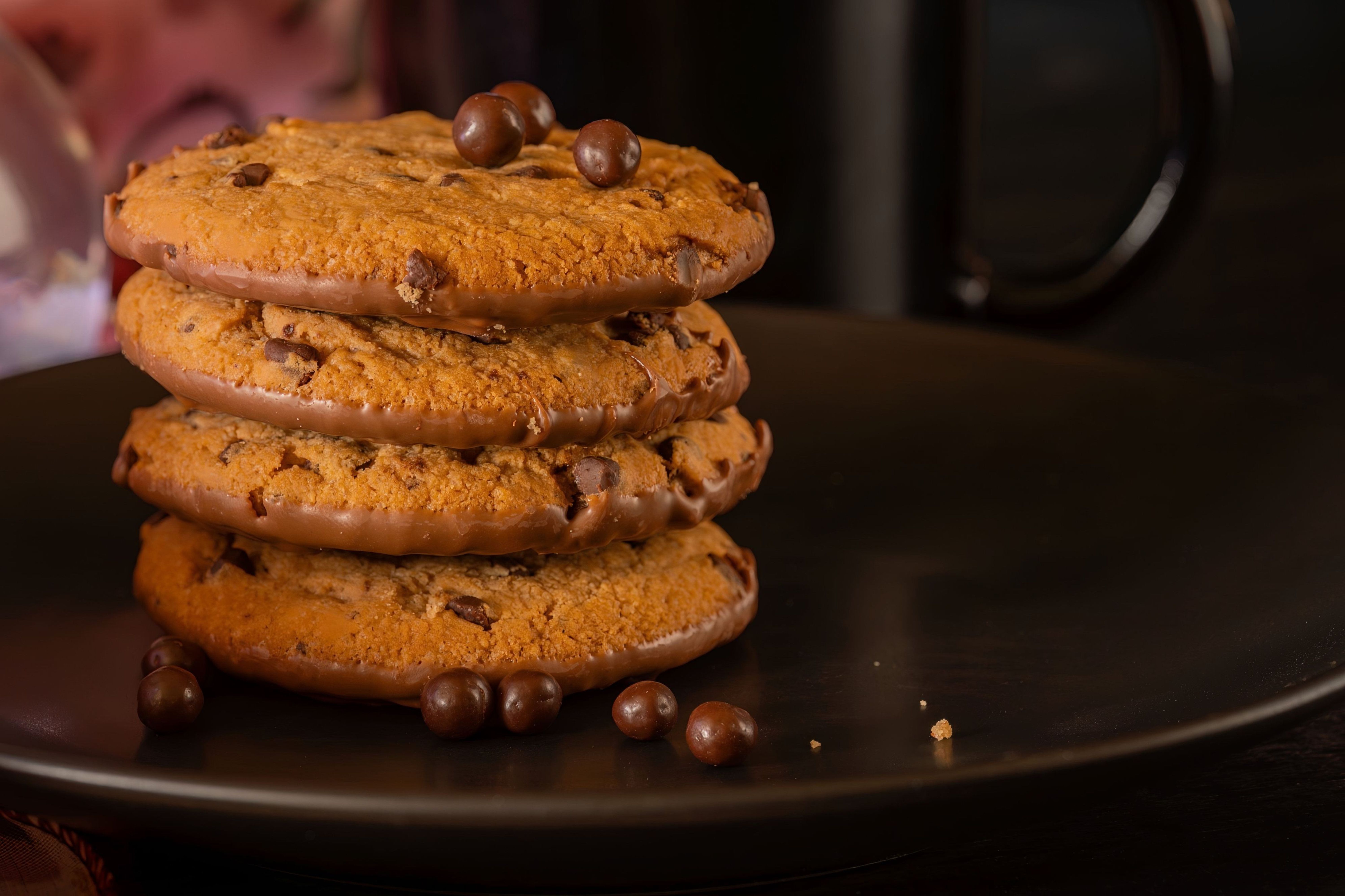 Delicious stack of chocolate chip cookies with chocolate balls on a plate, perfect for indulgent snack time.