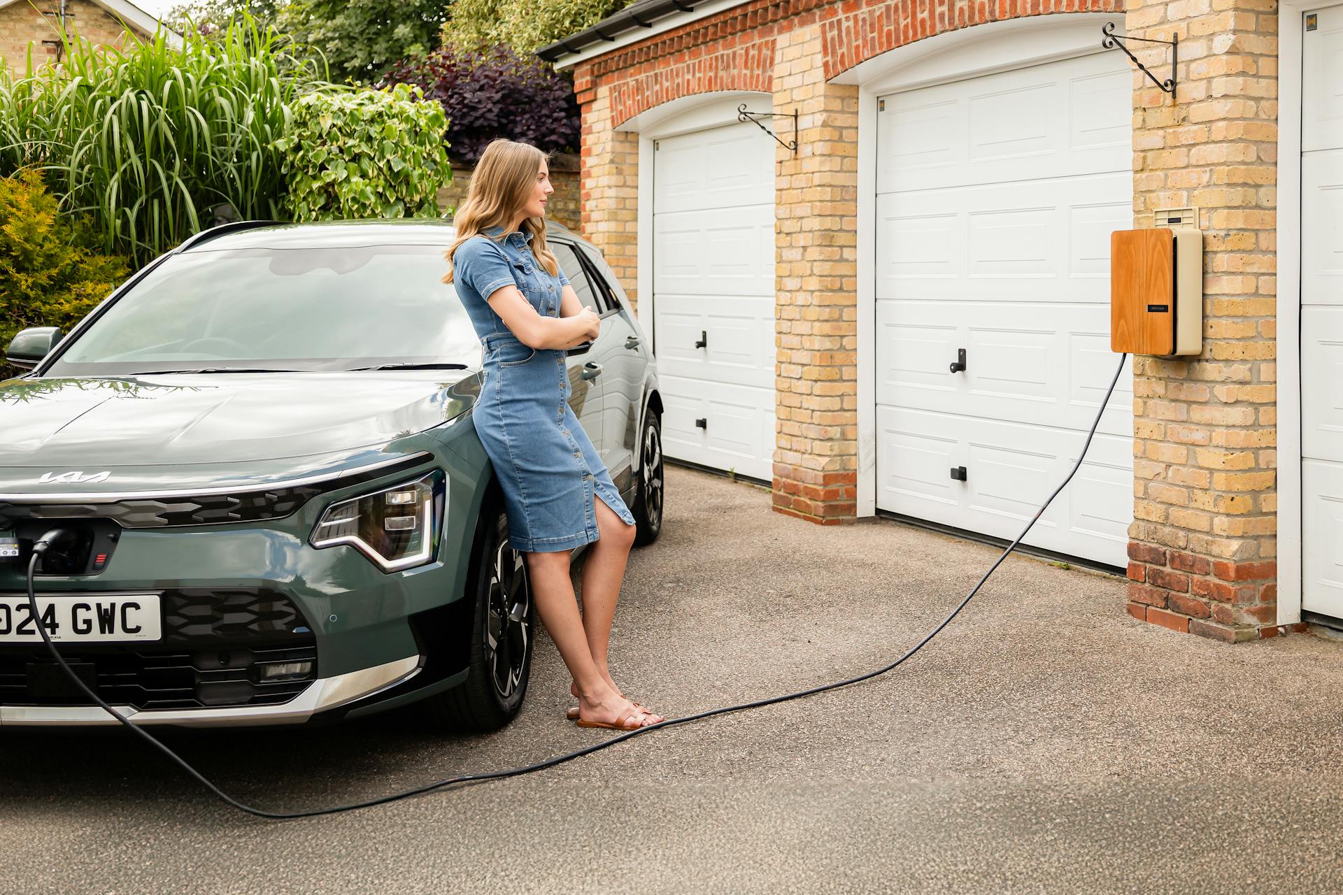 Young lady with an Andersen home electric vehicle charge point and all-electric Kia Niro