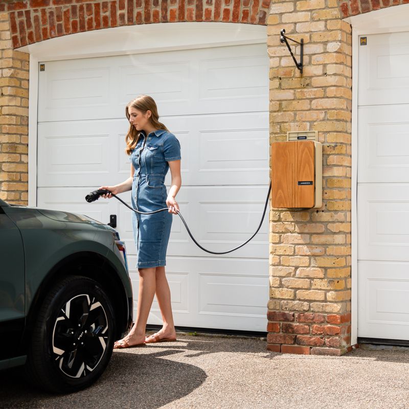 Driver connecting an electric vehicle to a wall-mounted home charger